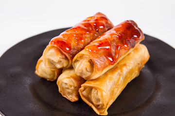 Chinese Traditional Spring rolls with sweet and sour sauce on a black plate