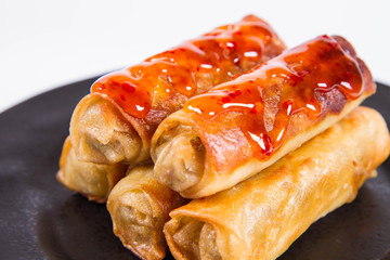Chinese Traditional Spring rolls with sweet and sour sauce on a black plate