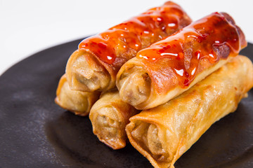 Chinese Traditional Spring rolls with sweet and sour sauce on a black plate