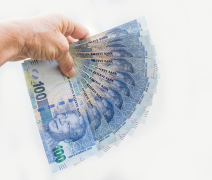 South African banknotes in hand.