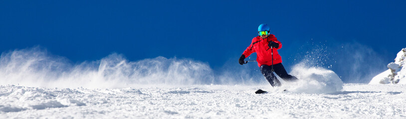 Man skiing on the prepared slope with fresh new powder snow - obrazy, fototapety, plakaty