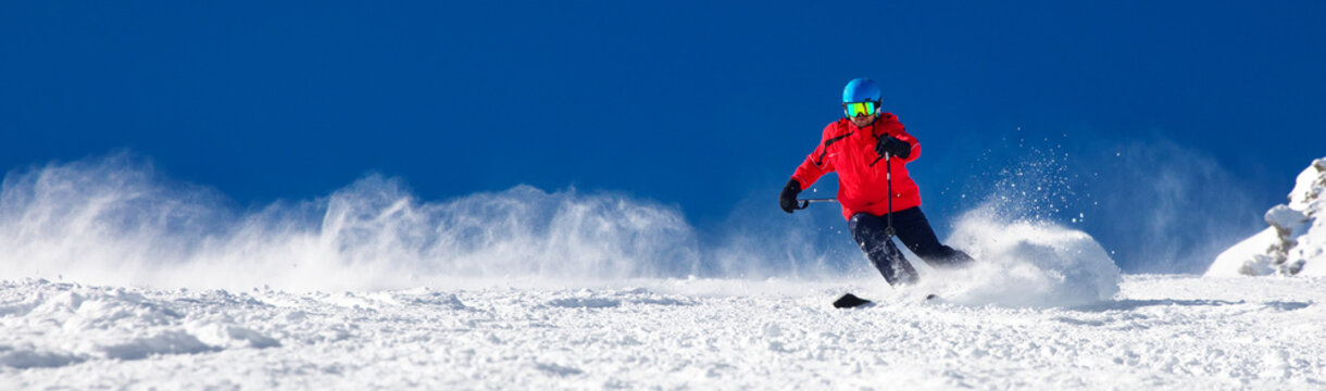 Man skiing on the prepared slope with fresh new powder snow