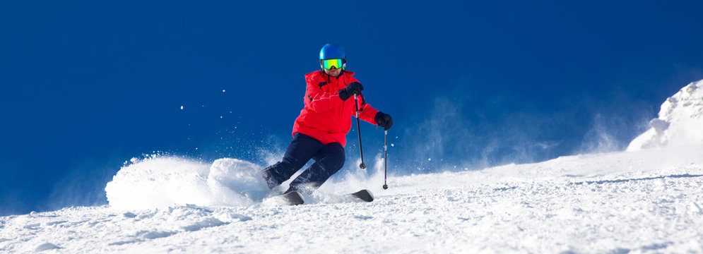 Man skiing on the prepared slope with fresh new powder snow