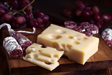 fuet spanish cheese and grape on wooden board