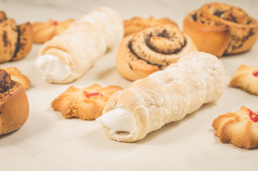 assortment of baked cookies and rolls with poppy/assortment of baked cookies and rolls with poppy on white table. Selective focus