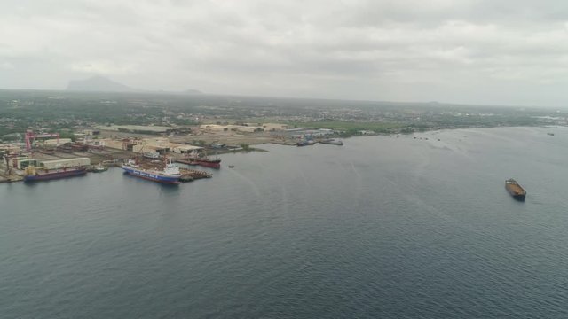 Aerial view cargo and merchant ships in harbor. trading vessels in the bay awaiting loading and unloading at the seaport. Batangas, Philippines.