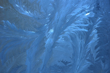 frosty pattern on the window draws winter blue color