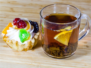 Black tea in a glass tea Cup, Shortbread, lemon, waffles, cakes baskets