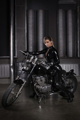 Fototapeta na wymiar Sexy biker girl in a latex on a motorcycle