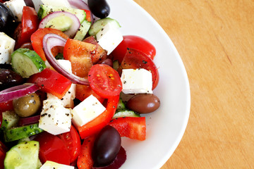 Greek Salad with green and dark olives served on white plate