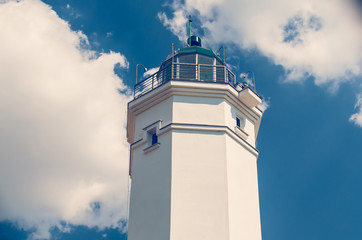 White lighthouse against the blue sky on a sunny day