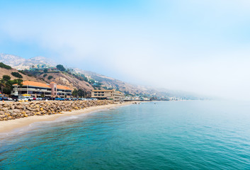 MALIBU, CALIFORNIA, USA - FEBRUARY 5, 2018: View of the foggy sandy beach in Malibu. Copy space for...