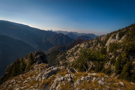 Scenic view from top of he Stadelwand grad to Rax valley, with grass, rocks and dark blue sky, Alpen, lower Austria