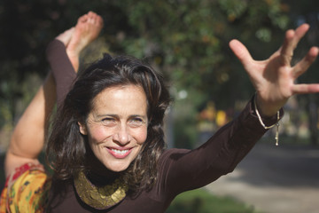 Lovely middle aged woman practicing yoga outdoors, on natarajasana pose, known as lord of the dance...