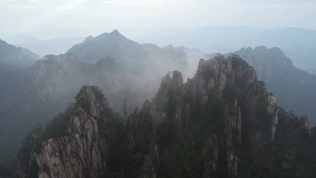 Drone shot of amazing mountain landscape in early morning fog, famous Huangshan national park in China