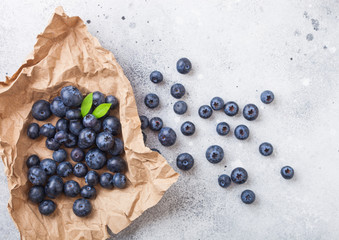 Fresh raw organic blueberries on brown paper on stone kitchen background. Space for text