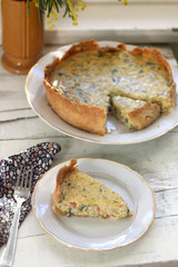 Slice of homemade quiche filled with cheese, ham and leek. Selective focus.