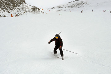 Mature skier fallen during downhill at ski resort in winter. Accident at ski slope due to unfasten...