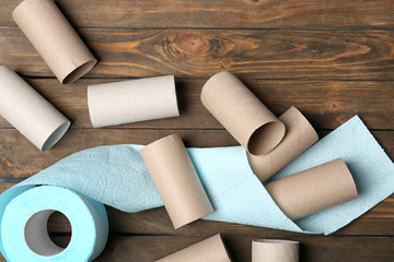 Flat lay composition with toilet paper and empty rolls on wooden background