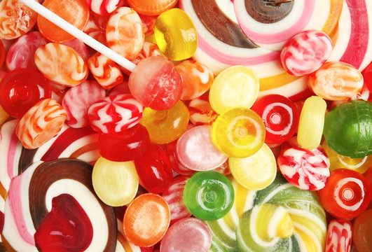 Different delicious colorful candies as background, top view