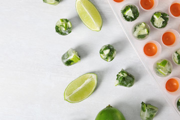 Composition with lime and mint ice cubes on light background, flat lay