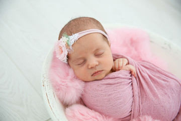 Fototapeta na wymiar Adorable newborn girl lying in baby nest, closeup