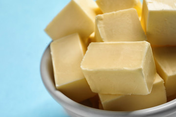 Bowl with fresh butter on color background, closeup