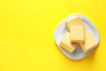 Plate with fresh butter and space for text on color background, top view