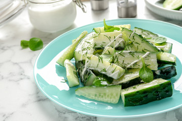 Plate with delicious cucumber salad on marble table, closeup
