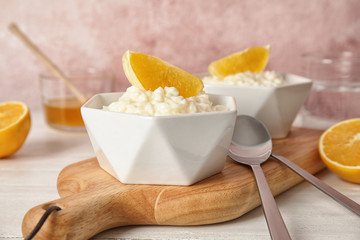 Creamy rice pudding with orange served on wooden table