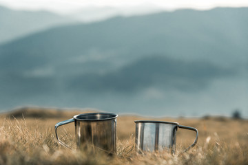 metal cups on a background of mountains