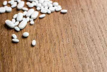 Fototapeta na wymiar Medicine pills on a wooden texture table