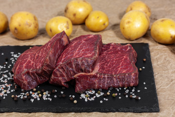 The cut of marbled beef on slate and butcher paper