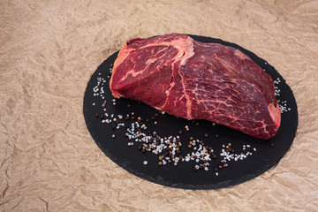 The cut of marbled beef on slate and butcher paper
