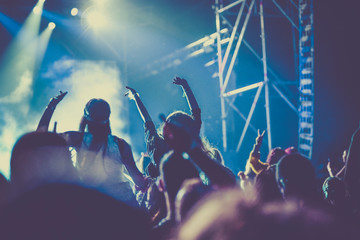 Naklejka premium cheering crowd with raised hands at concert - music festival