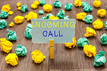 Text sign showing Incoming Call. Conceptual photo Inbound Received Caller ID Telephone Voicemail Vidcall Clothespin holding gray note paper crumpled papers several tries mistakes