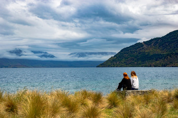 girls sitting by the lake