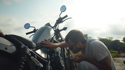 Young man searching the internet the reason his motorbike broken