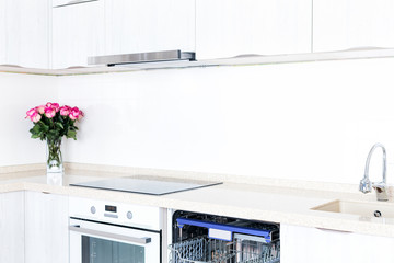 Dishwasher and beautiful bouquet of flowers in kitchen interior, no people
