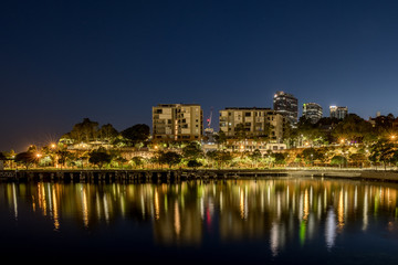Fototapeta na wymiar Apartments at night and reflection on the bay