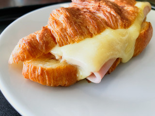Croissant ham cheese on white dish