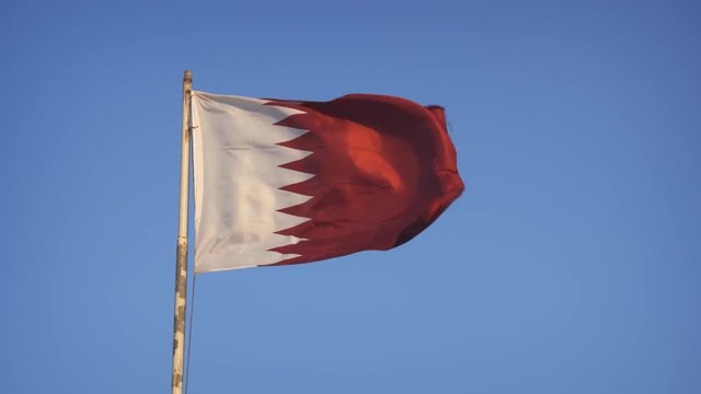 Qatari flag, with its fields of white and red divided by a jagged line