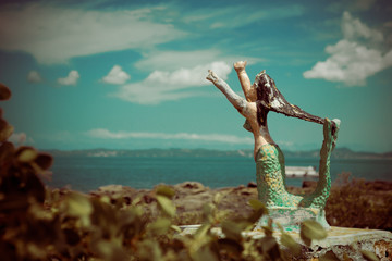 Statue of an abandoned mermaid on the beach