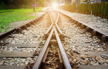 train tracks on gravel, two of railways tracks merge  with sunset background, concept of success