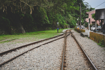 Fototapeta premium train tracks on gravel, two of railways or railroads tracks merge in a rural scene background, concept of journey