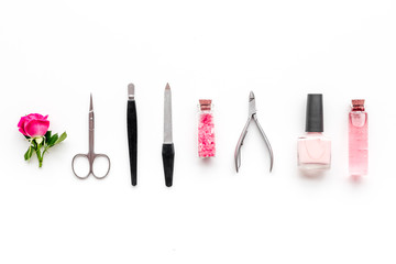 manicure equipment with nail polish and rose petals white background top view space for text