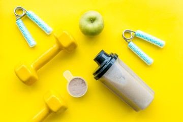 sport diet with protein nutrition and fitness equipment on yellow background top view mock up