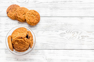 Homemade oatmeal cookies in glass bowl on white woden background top view copy space