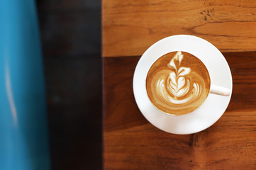a cup of latte art coffee on wooden background