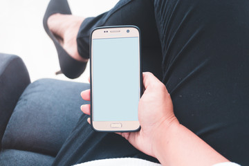 Back view close up of a woman hand using a smart phone